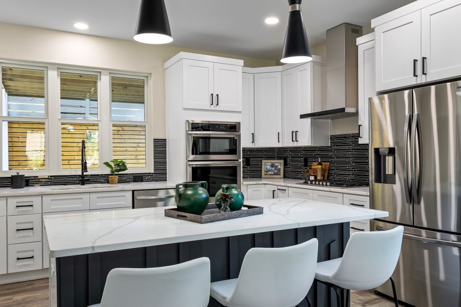 Modern kitchen renovation with a quartz-topped island and updated cabinetry showing successful project completion